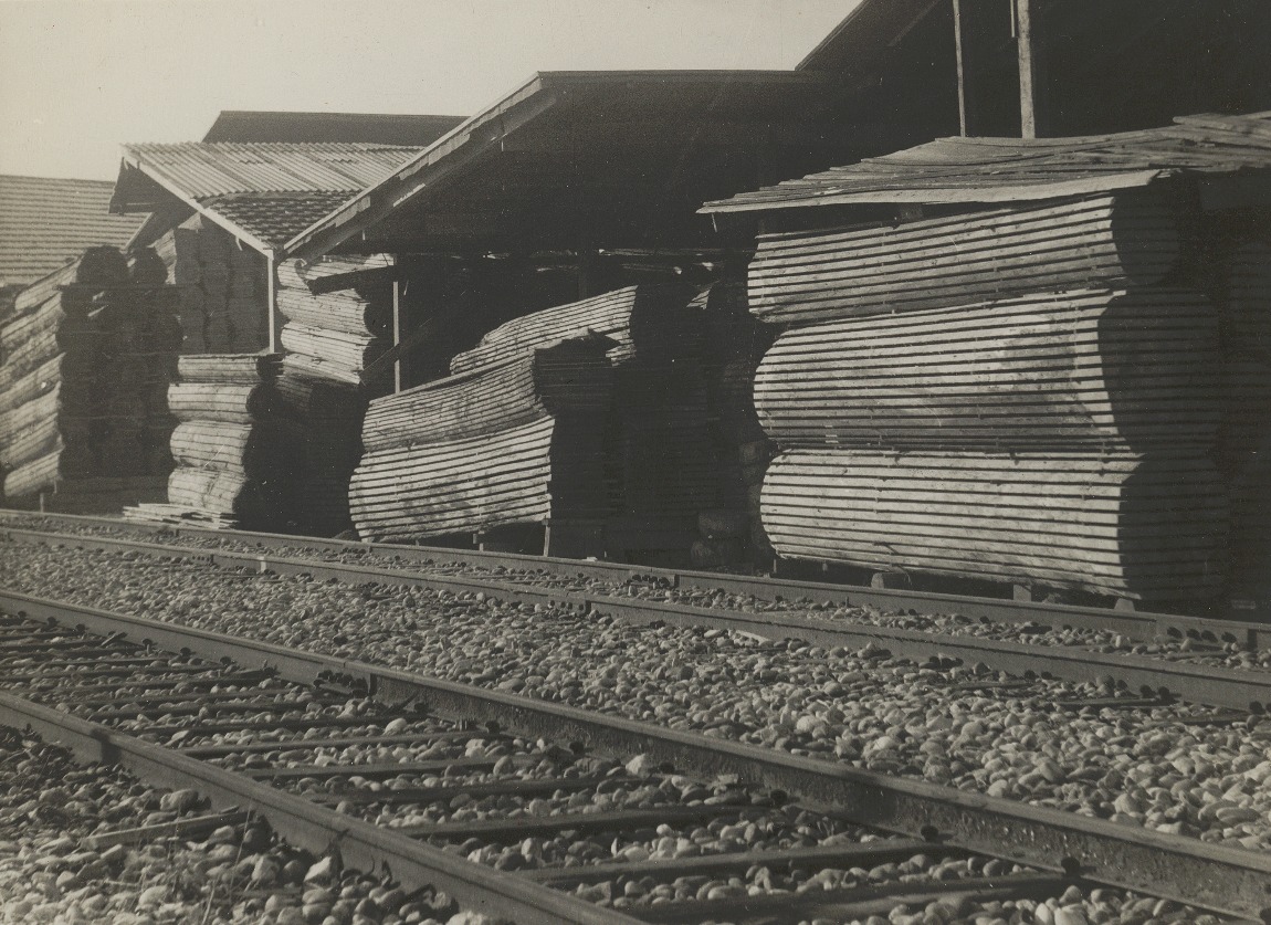 Das Holzlager der Schreinerei, hier von der Eisenbahnseite her gesehen, füllte zwei Drittel des 1500 m2 grossen Lagerplatzes, auf dem anderen Drittel lagerte die Firma Rapp Material für den Strassenbau. Um 1940. (Archiv Schwald Fenster AG)